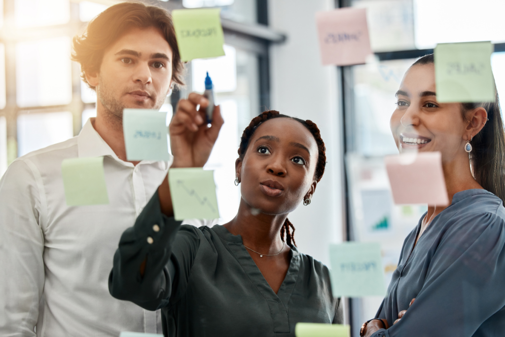 diverse office team collaborating on strategic workforce planning using sticky notes and storyboard