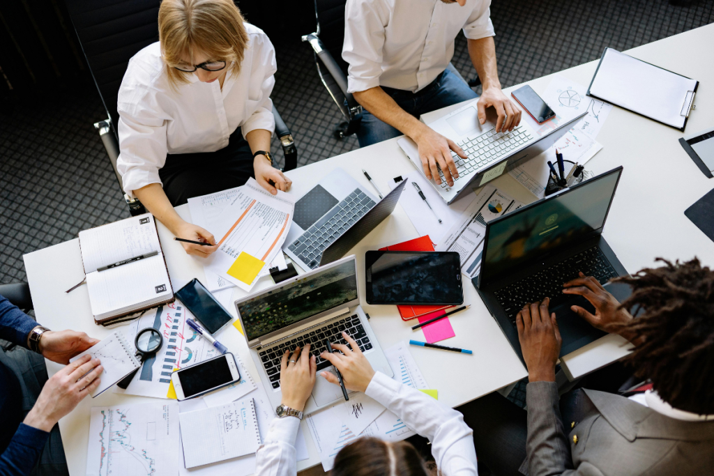 A professional woman sitting at a computer desk actively using HR software tools in a modern office