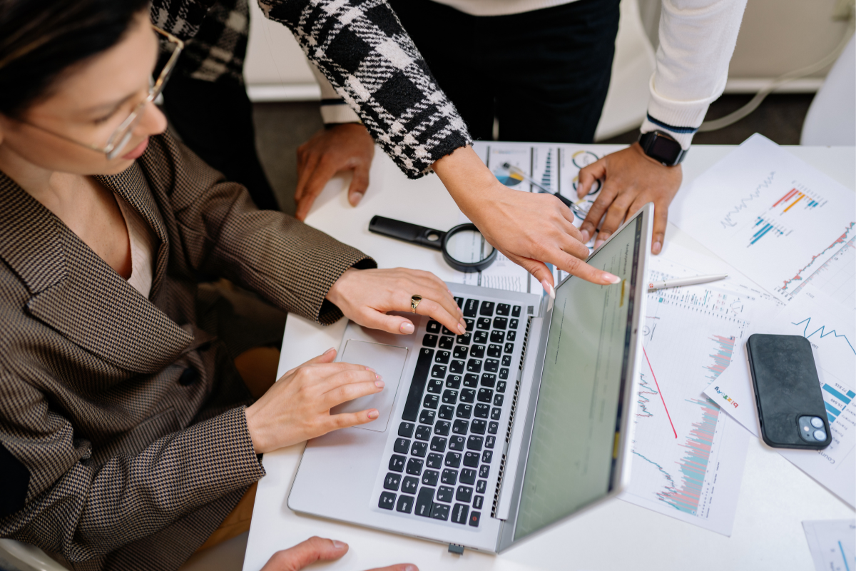 Manager reviewing a workforce productivity metrics dashboard with a professional services team in a meeting room
